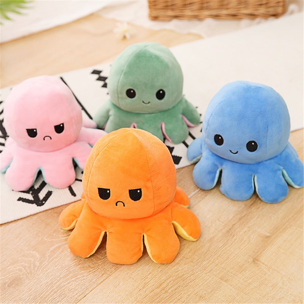Four colorful plush octopus toys on a wooden surface.