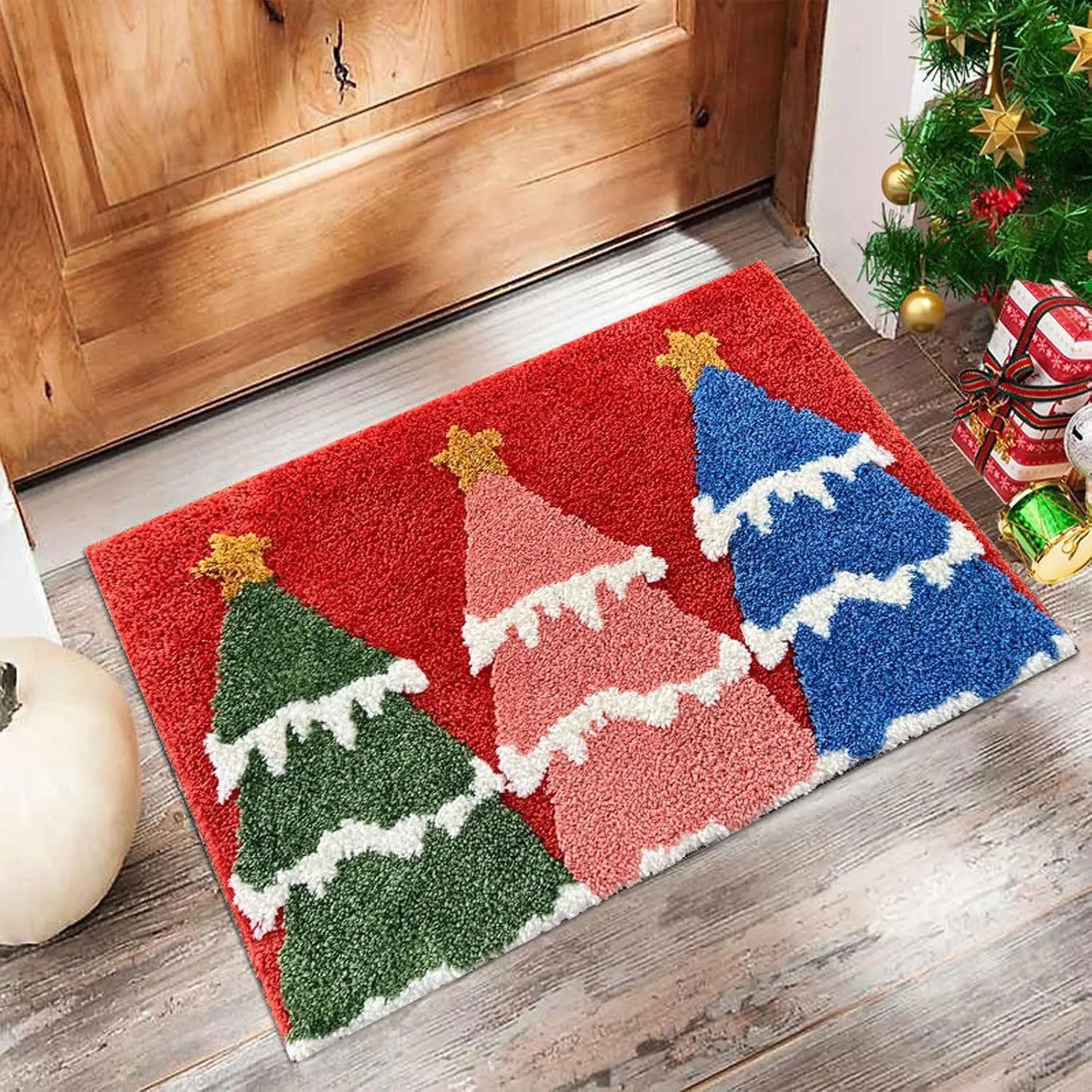 Decorative doormat with Christmas tree design on a wooden floor.